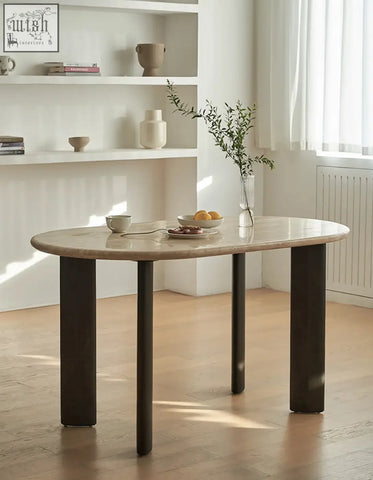 A sleek oval dining table with travertin marble top and dark solid wood cylindrical legs perfect for dining spaces