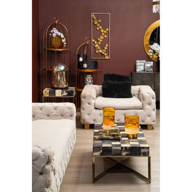 Gold-toned birdcage shelf with glass enclosures and decorative items beside ophelia 3 seat beige velvet sofa