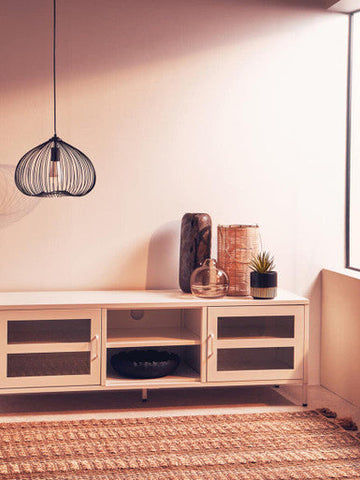 A minimalist white media console with glass-paneled doors and open shelving styled with an optik bottle vase