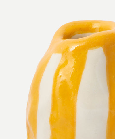 A glossy ceramic candle holder with bold dripping yellow stripes on white called orange candy stripe candle holder