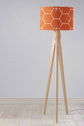 Orange lampshade with white hexagon pattern on a light wood tripod base table lamp design