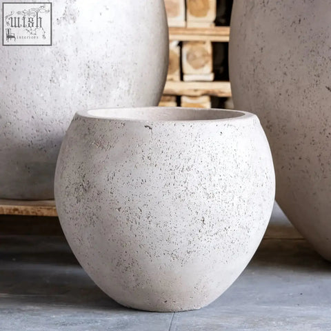 Orbello 55cm planter is a large 82l round concrete planter with a speckled gray finish and a flared rim