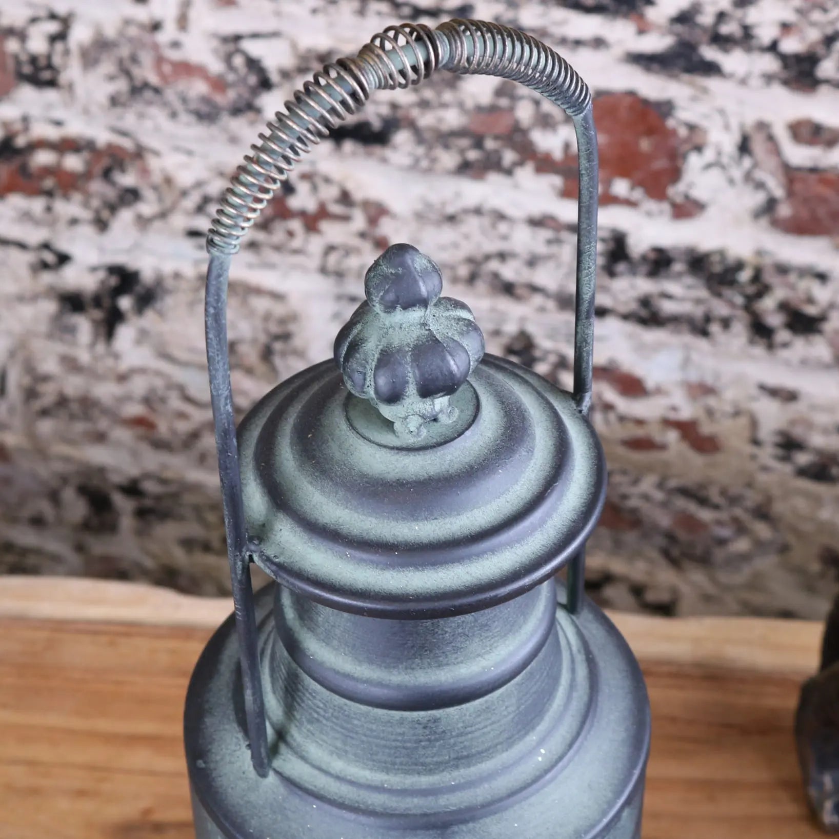 Antique-style metal railway lantern with verdigris patina and coiled spring handle in orchha vintage style