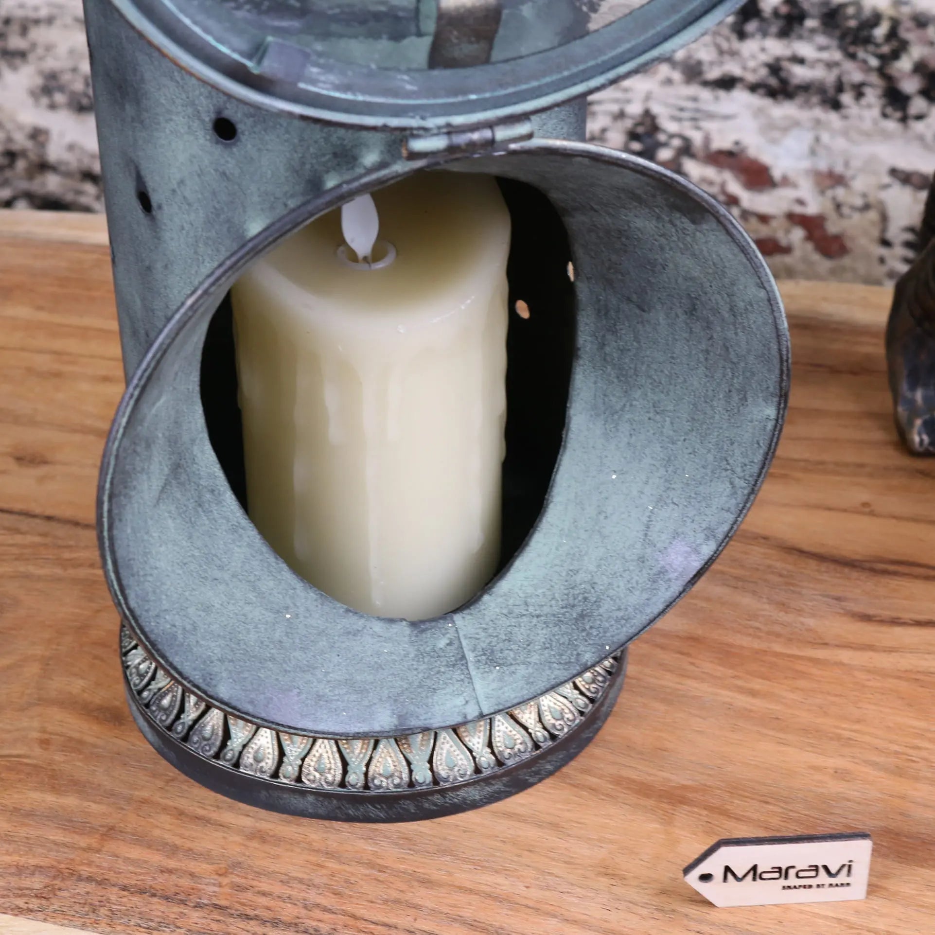 Antique metal orchha vintage style railway lantern with weathered green patina and silver leaf base housing white candle