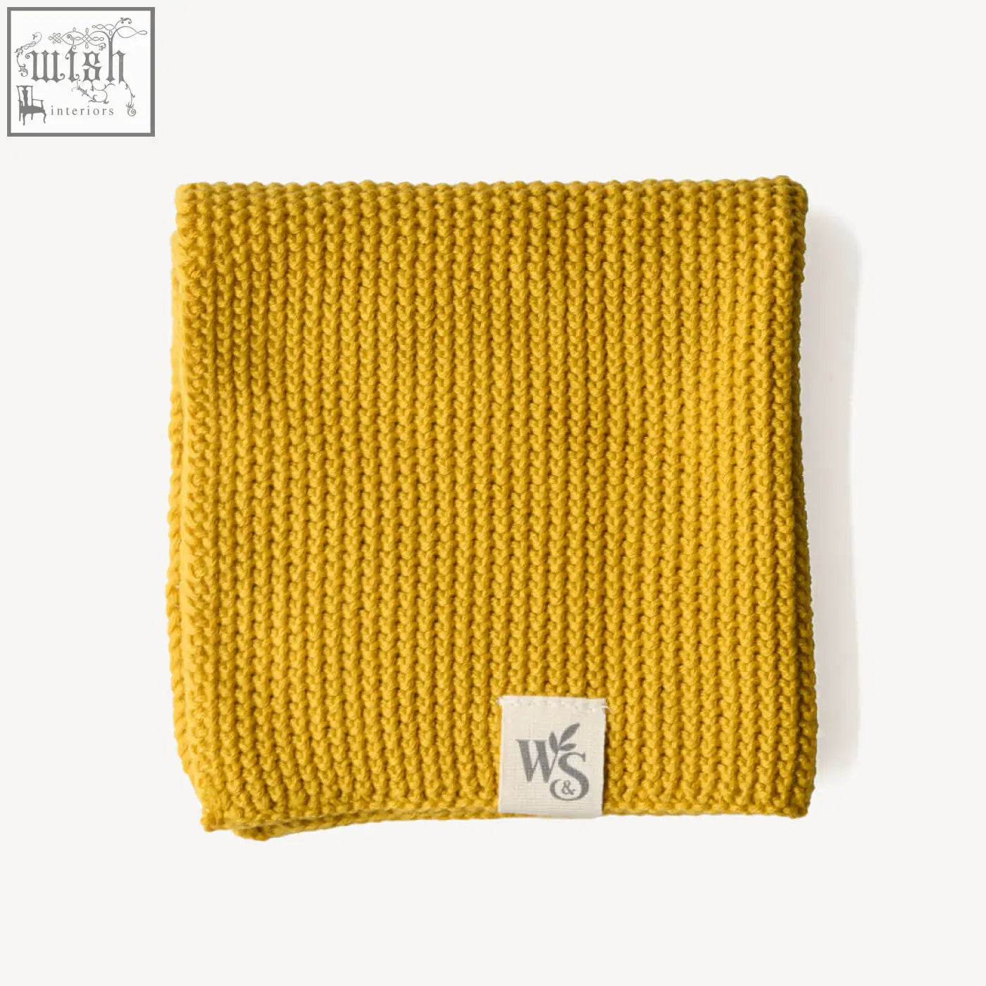 A mustard-yellow knitted organic cotton scarf with ribbed texture and a ws amp label perfect for cotton dishcloths