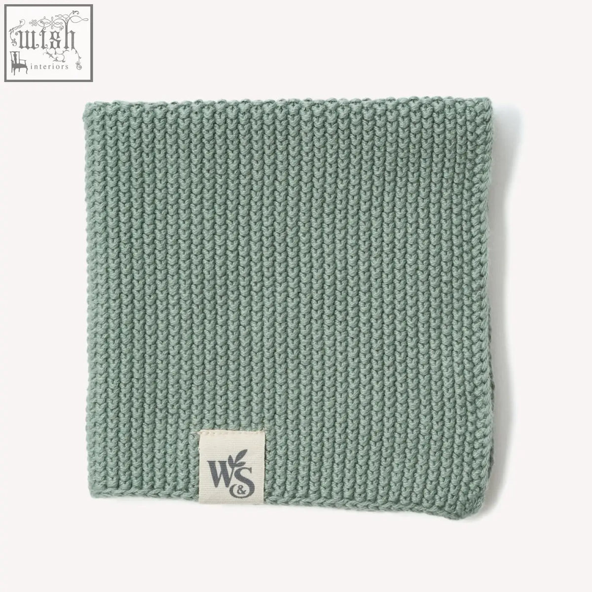 A soft sage green knitted organic cotton dishcloth with a ribbed pattern and a white w&s label