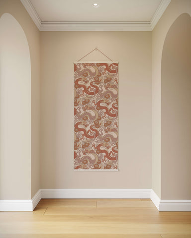 A rectangular oriental dragon tapestry with red and beige dragons on textured fabric hanging by a wire hanger
