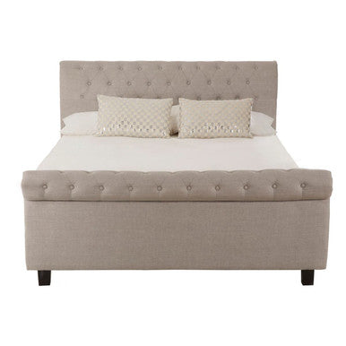 Beige tufted light grey ottoman king bed with matching storage base and dark wooden legs for extra storage