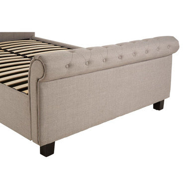 Beige upholstered sleigh bed with tufted headboard and dark wooden legs in light grey ottoman king style