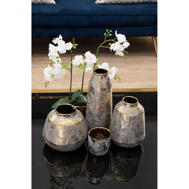 Set of four distressed grey ceramic vases in silver and gold tones arranged on a reflective surface