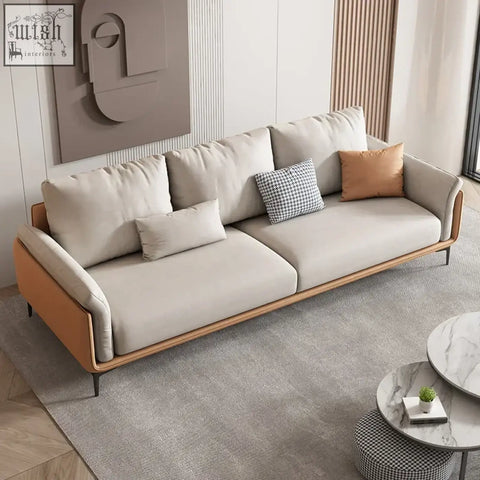 Oslon sofa with beige upholstered plush cushions wooden frame and orange leather accents minimalist design