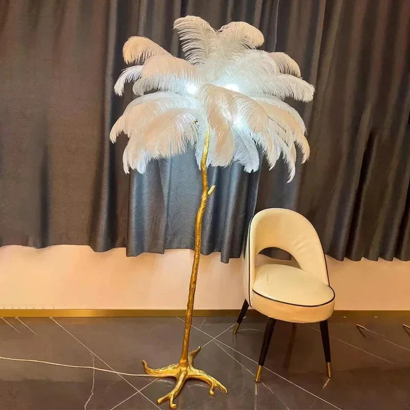 A floor lamp with a copper resin base shaped like an ostrich feather tree topped with glowing white feathers for bedside use