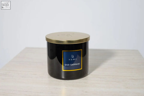 Black cylindrical large candle with gold lid and label featuring li home oud sapphire scent from large candle collection
