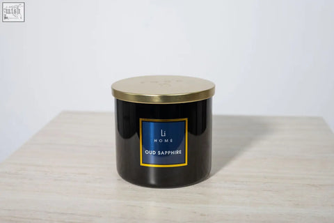 Black cylindrical oud sapphire luxury candle with gold lid and blue label from li home large candle collection