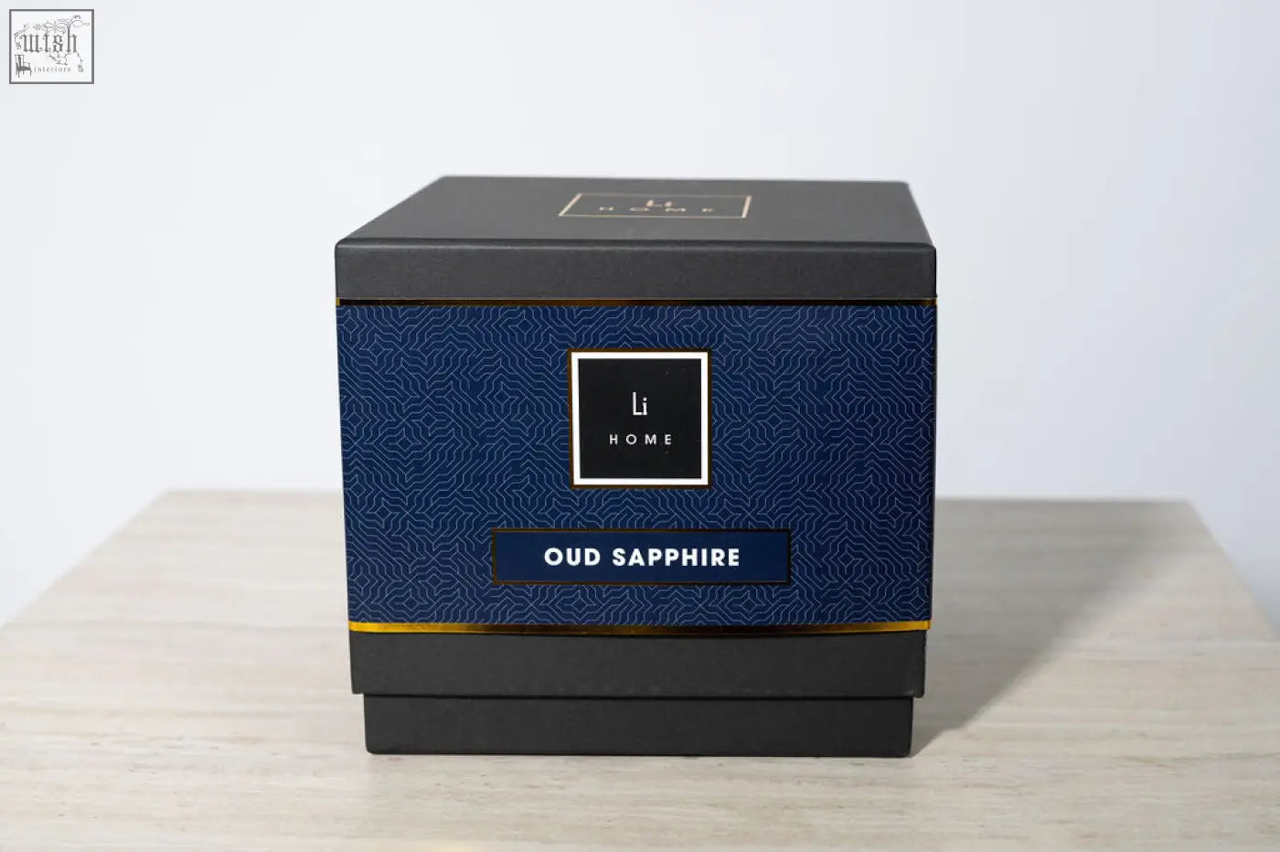 A sleek navy blue and black rectangular box with gold trim and li home logo for oud sapphire 3 wick luxury candle