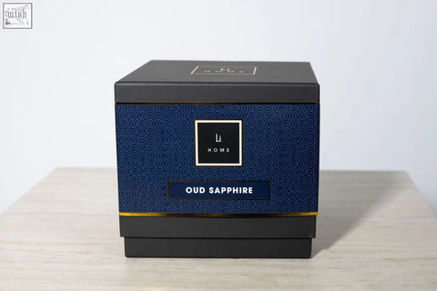A sleek navy blue and black rectangular box with gold trim and li home logo for oud sapphire 3 wick luxury candle