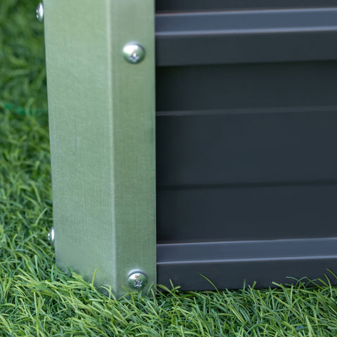 Green metal post with silver screws securing grey galvanized steel raised garden bed panel with installation gloves