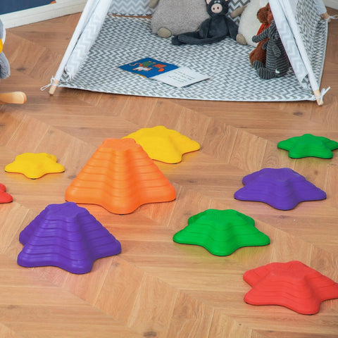 Brightly colored plastic star-shaped outsunny balance stepping stones in orange purple green yellow and red on wooden floor
