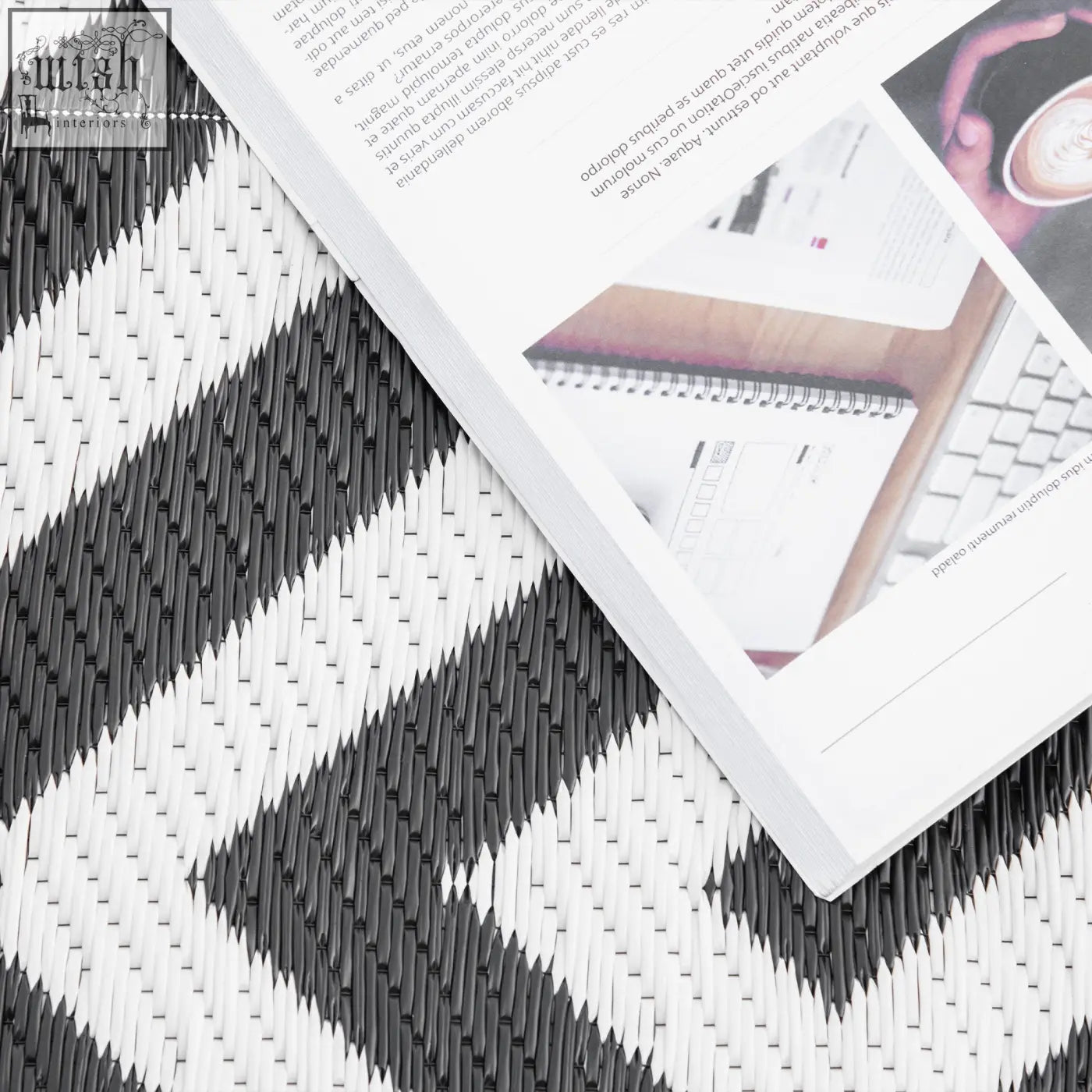 Black and white outdoor rug with geometric zigzag pattern made of plastic straw perfect for road tour and camping