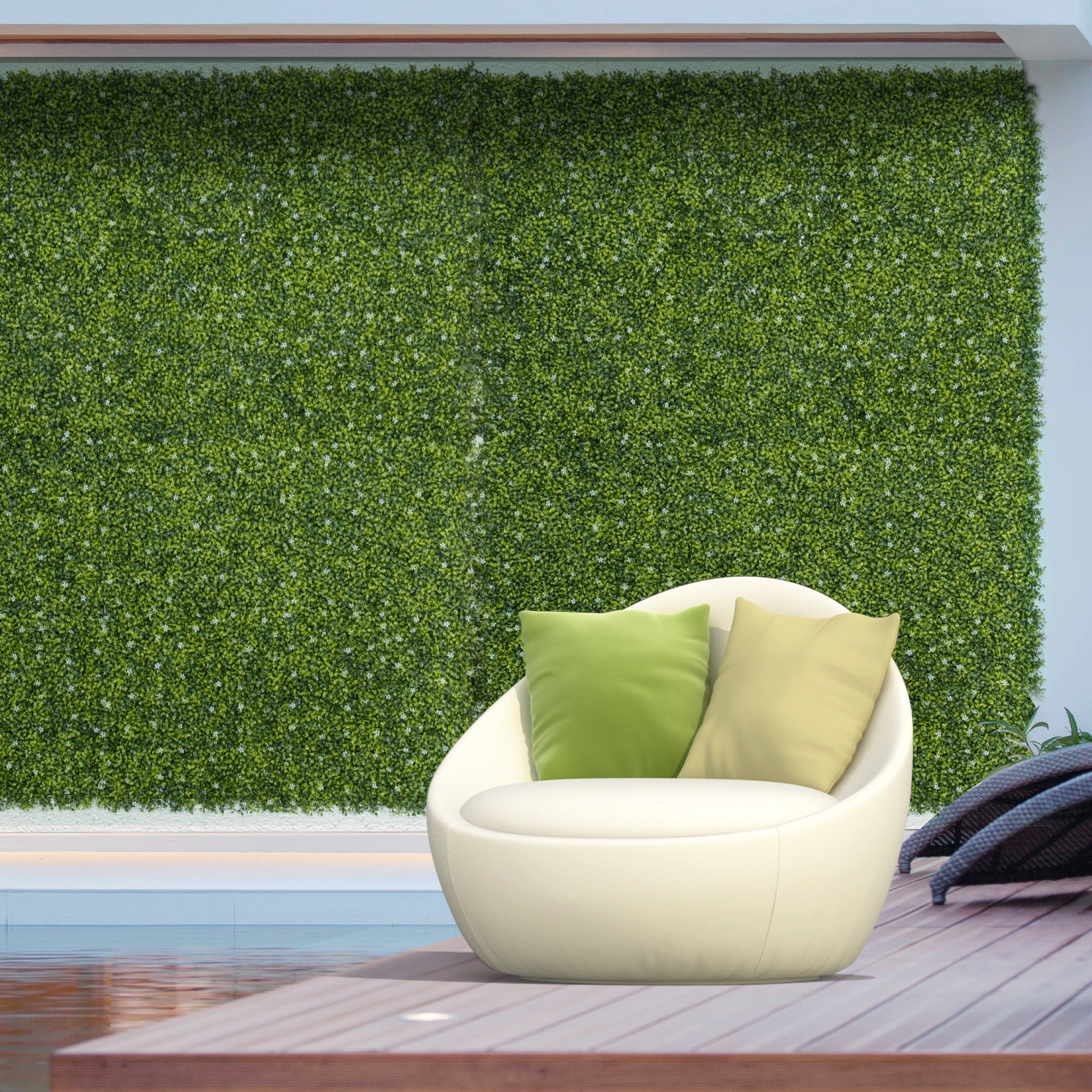 Cream-colored modern egg-shaped lounge chair with two green pillows beside milan grass 50cm x 50cm wall panel backdrop