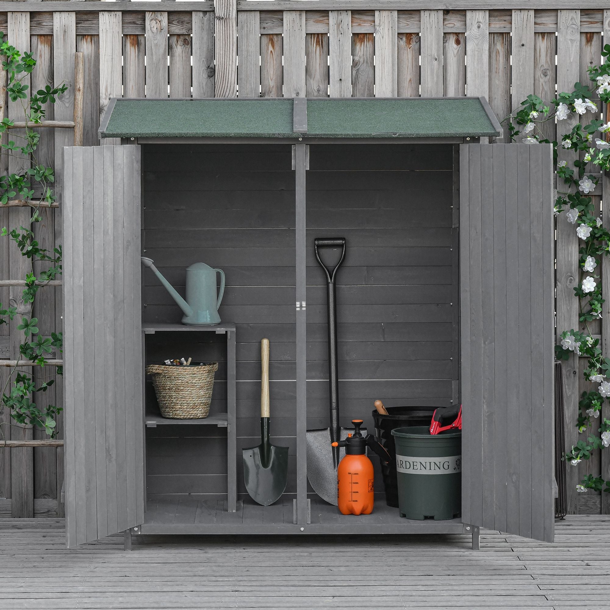 Gray wooden outsunny garden storage shed with green asphalt roof and open doors showing organized gardening supplies inside