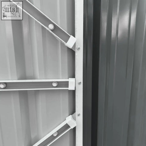 White metal support brackets with plastic connectors securing a gray corrugated panel on an outsunny outdoor garden storage shed
