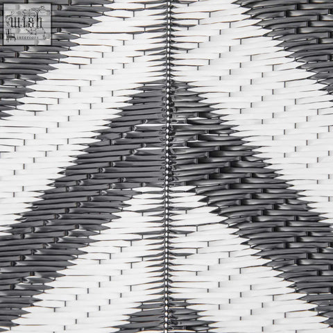 Black and white woven plastic straw outdoor rug with central seam perfect for road tour camping and picnics
