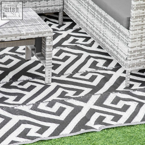 Black and white geometric outdoor rug with woven plastic straw texture perfect for road tour and camping use