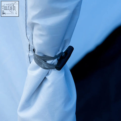 Black plastic toggle with gray mesh strap securing white fabric sleeve on sky blue outsunny tent porch with air vents