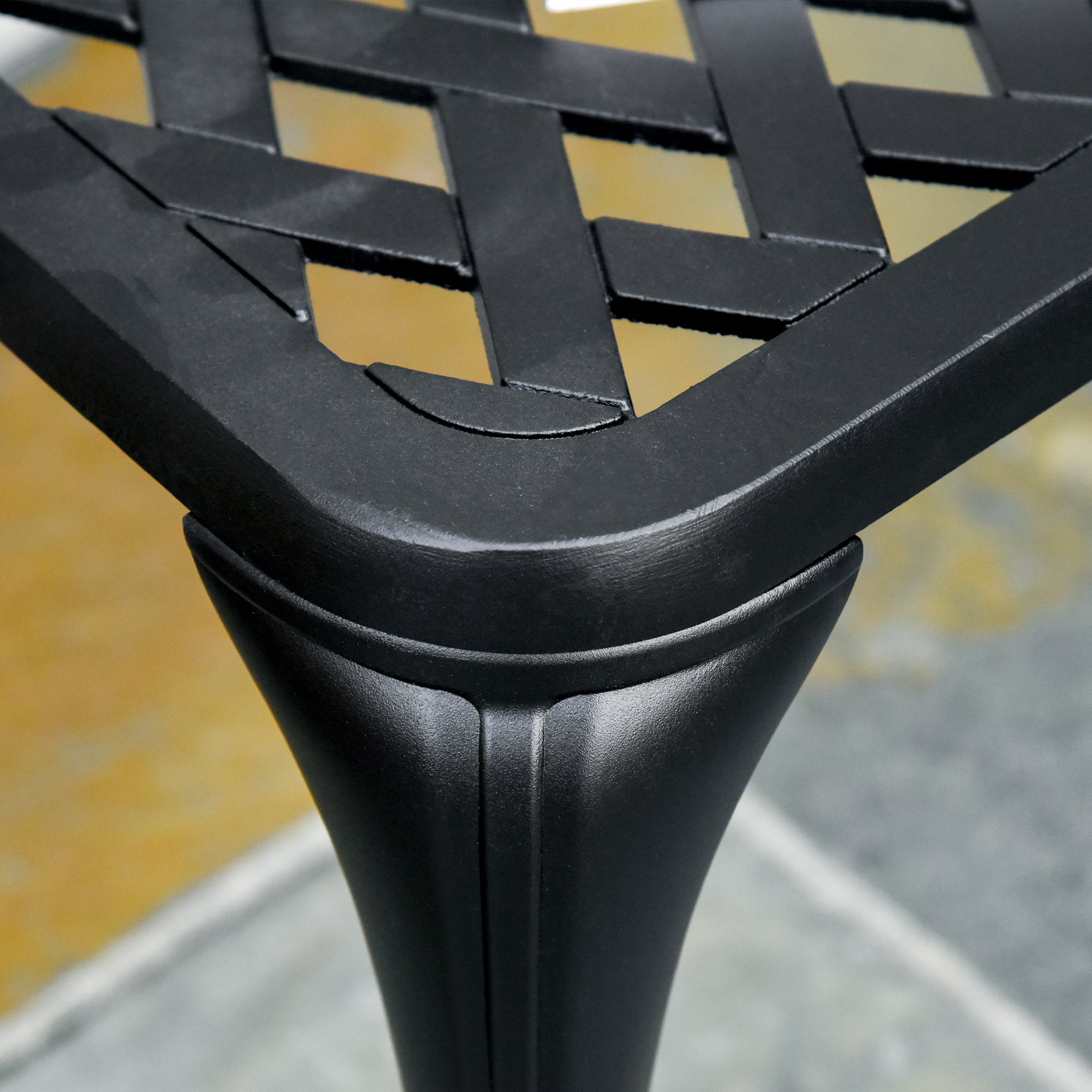 Black wrought iron garden bench with woven lattice top fluted tapered legs and curved line cast aluminium design