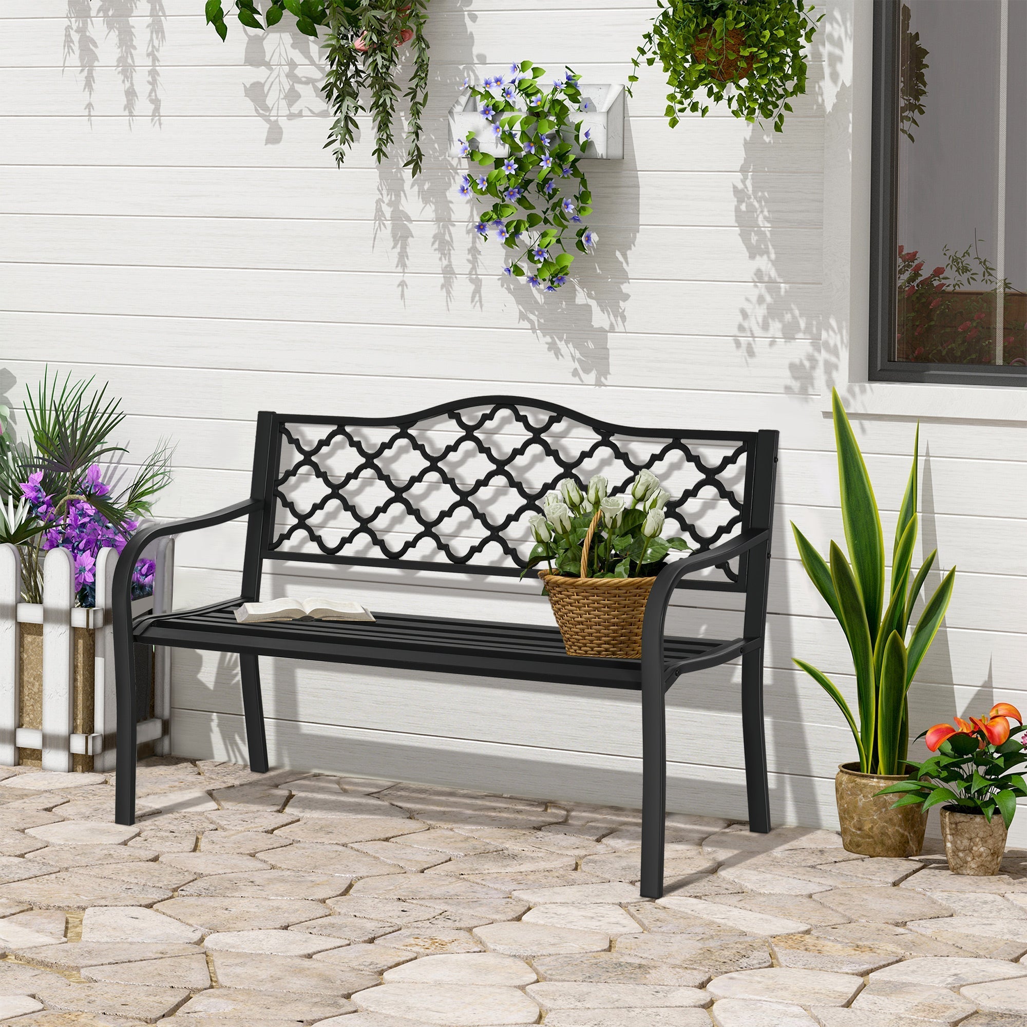 Black cast iron garden bench with lattice back and armrests featuring woven wicker basket on seat for yard or patio