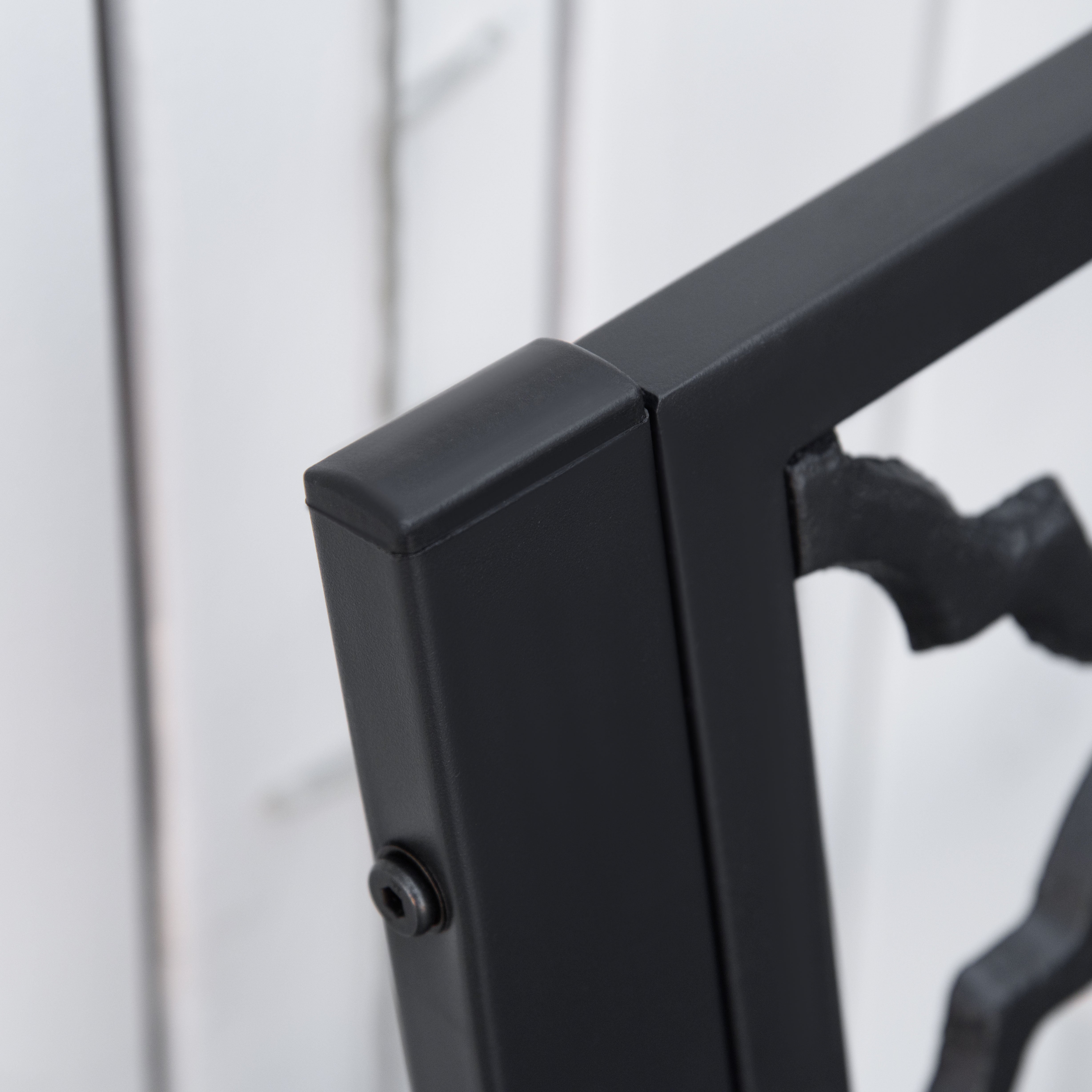 Black metal frame corner with matte finish and ornate scrollwork on outsunny cast iron garden bench for yard and patio
