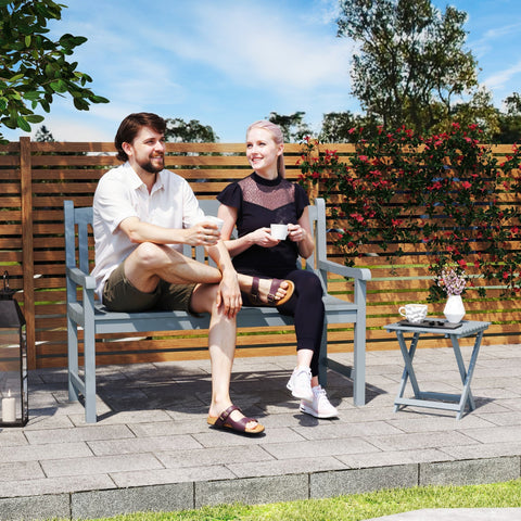 Gray poplar wood garden bench with slatted back and armrests for outdoor patio or porch seating