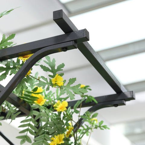 Black metal garden trellis arch with elegant scrollwork and curved supports decorated with yellow flowers and climbing vines