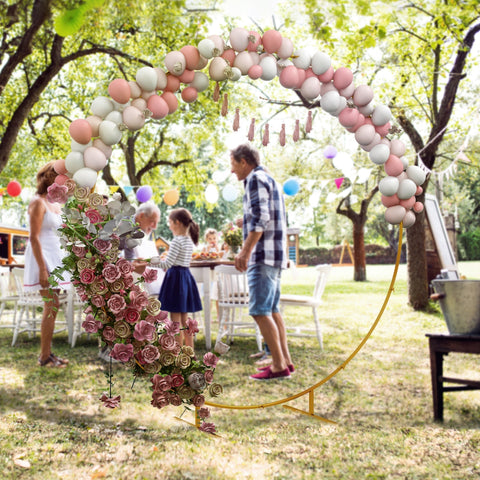 Decorative balloon arch with pink white cream balloons and tassels on gold tone wedding arch stand for parties