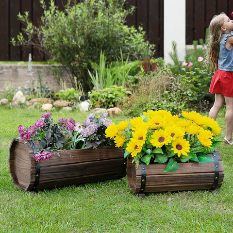 Two dark brown solid wood barrel planters with carbonized colour and black leather straps for vibrant flower beds
