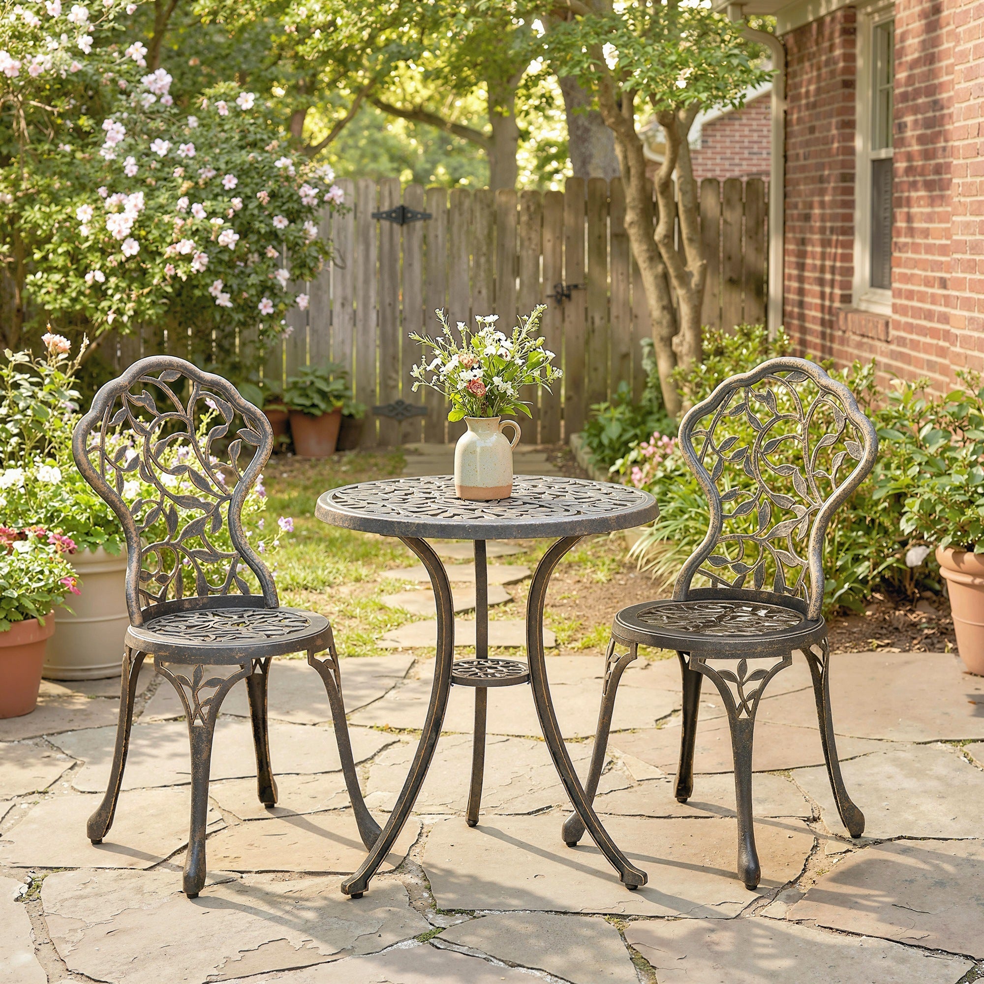 Black wrought iron bistro set with two chairs featuring ornate leaf legs and under-shelf for outdoor patio use