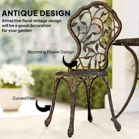 Antique-style wrought iron bistro set with two chairs featuring dark bronze finish and intricate floral patterns