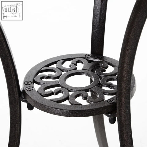Black wrought iron circular plant stand with ornate scrollwork design in cast aluminium garden furniture set brown
