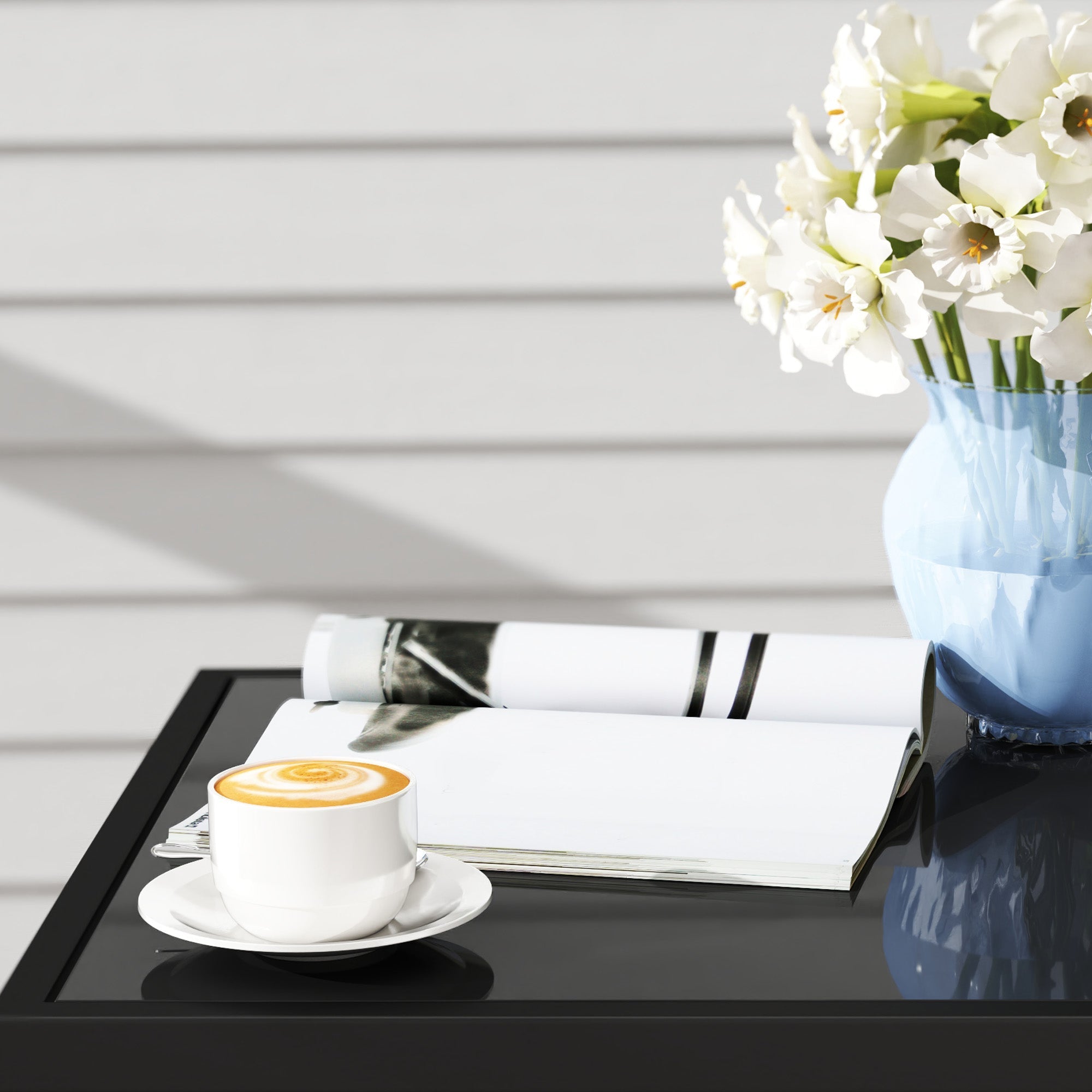 White ceramic coffee cup with latte art on grey glass top table of outsunny rattan bistro set for outdoor patio