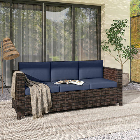 Dark brown rattan sofa with dark blue cushions and beige throw blanket for three persons outdoor use