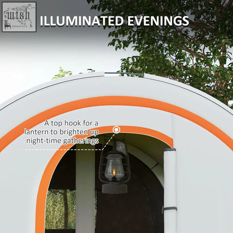 Vintage-style black metal lantern with glowing flame hanging from arched cream and orange family tent with carry bag included