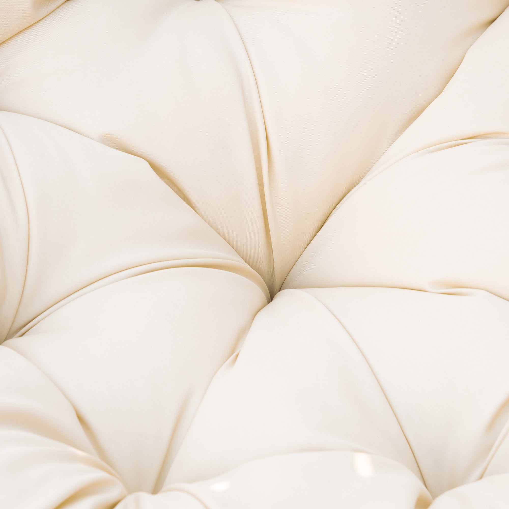 Cream-colored tufted fabric with soft sheen on beige outsunny 360-degree swivel chair with steel frame underneath