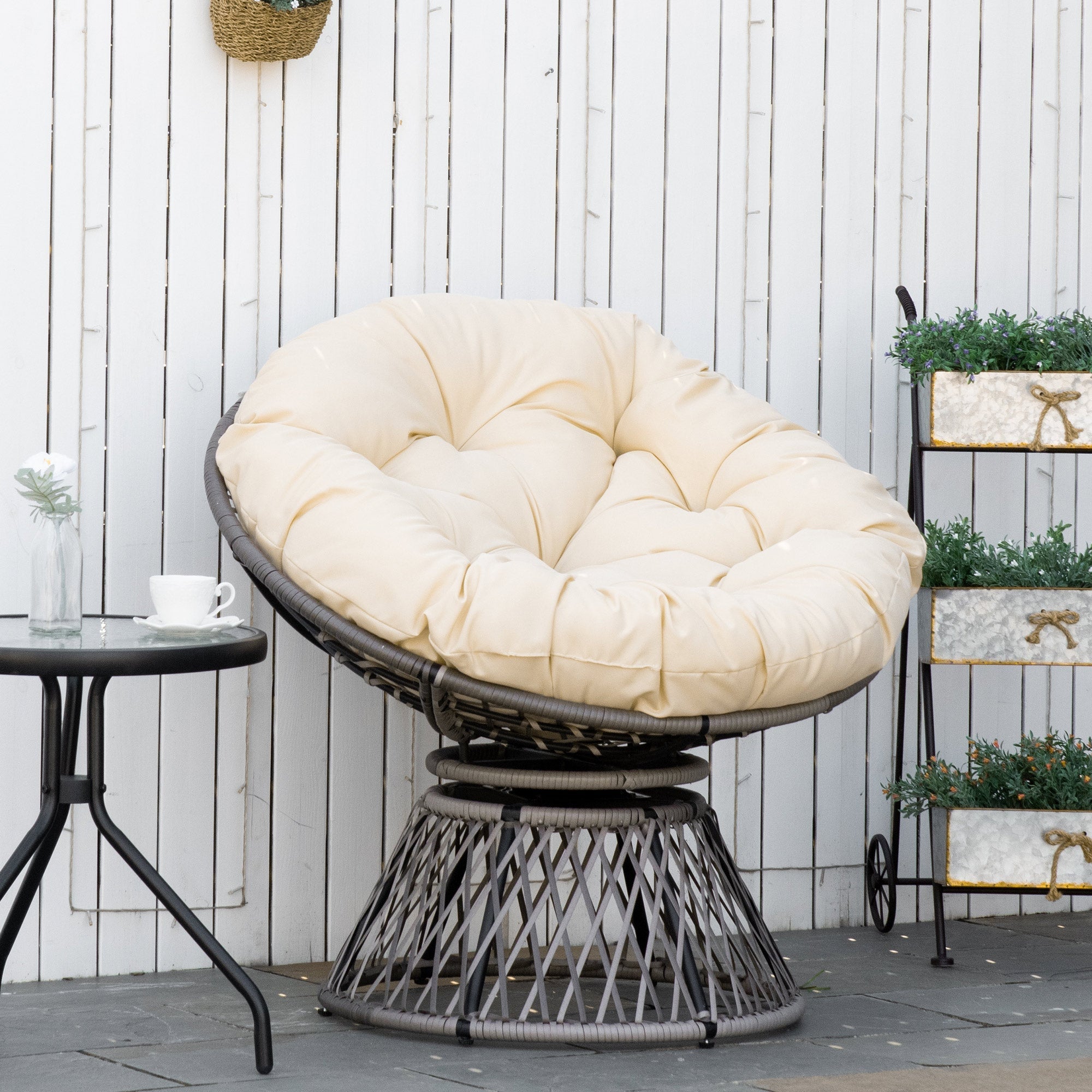 Cream cushioned papasan chair with dark gray woven wicker frame and steel frame underneath 360-degree swivel base