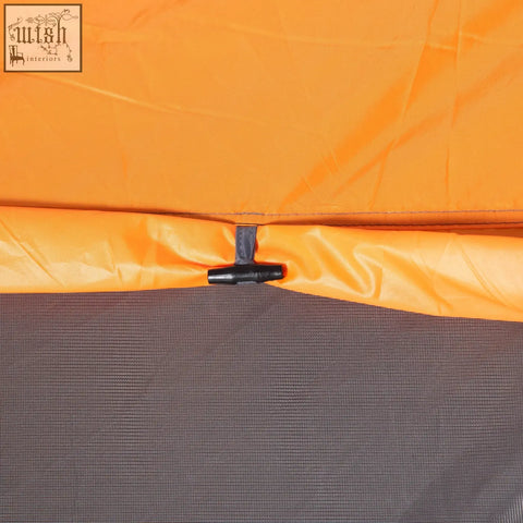 Orange pop-up camping tent fabric with black buckle securing top edge to gray mesh base for easy access mesh windows