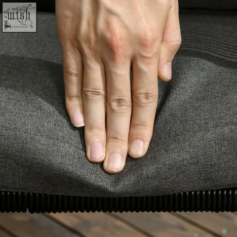 A hand resting on a dark gray cushion with black ribbed edge from outsunny seater rattan cube garden furniture set