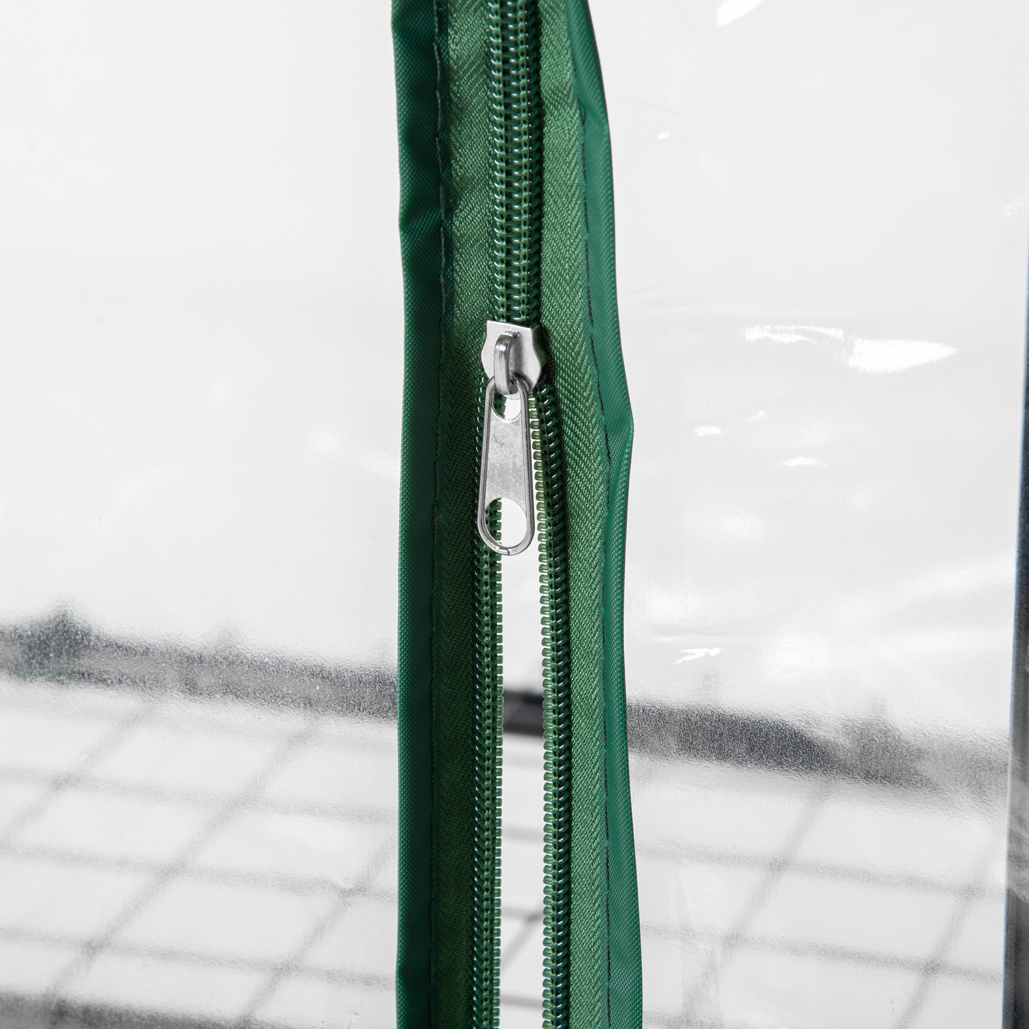 Green zipper with silver pull tab on outsunny mini portable greenhouse pvc cover with powder coated steel frame and four inside shelves