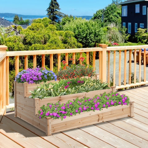 Outsunny 470l wooden raised bed with stepped design and light wood filled with purple and red flowering plants