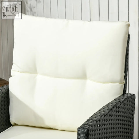 Cream-colored plush cushion with tufted design on dark woven rattan garden sofa with steel frame and coffee table