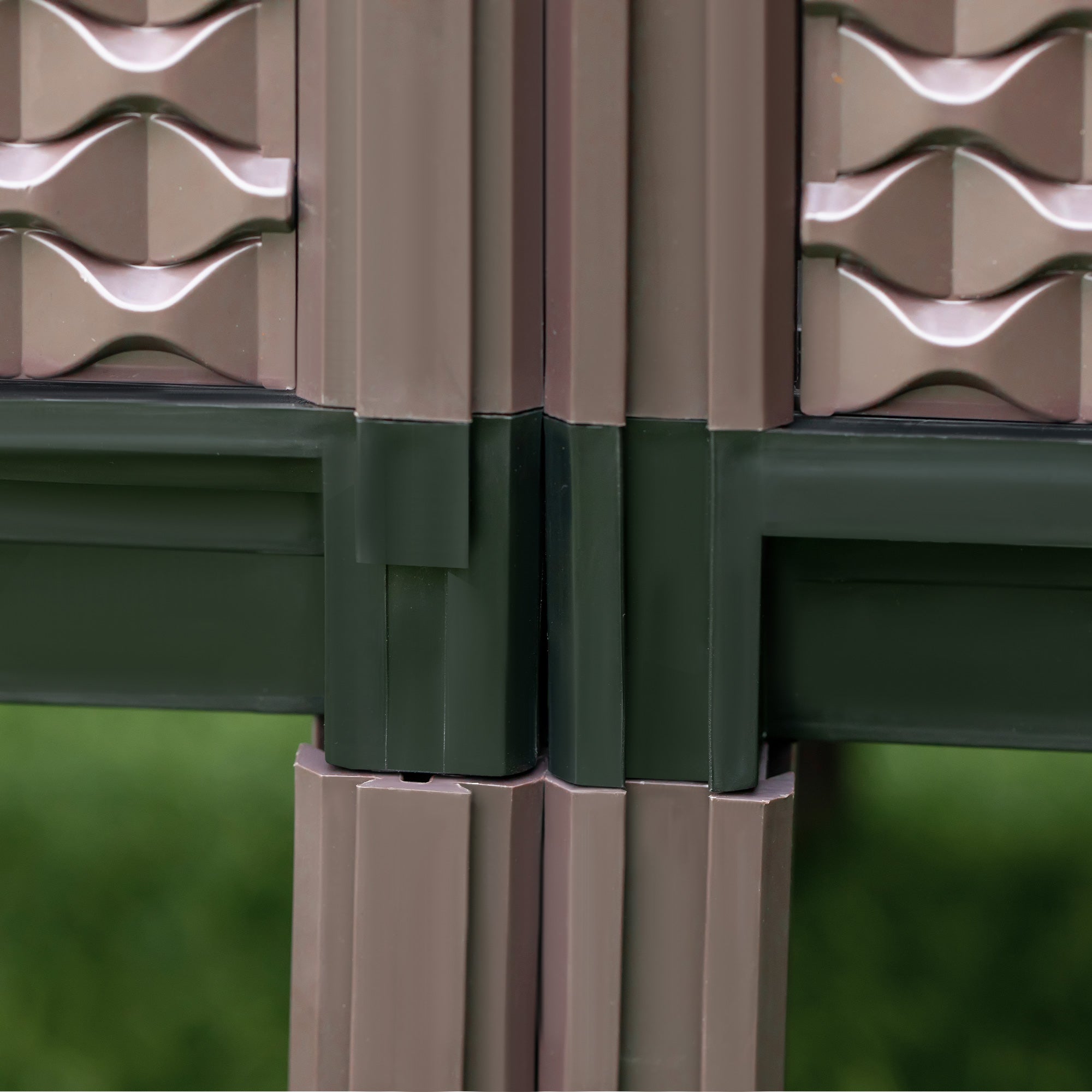 Beige and dark green plastic garden trellis with wavy textured panels for planter box with drainage holes to grow plants